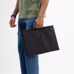 Male model holding black Basalt Pivot laptop sleeve in denim jeans | KlippiK Kuwait