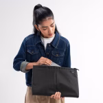 Female model in denim jacket opening black laptop sleeve | KlippiK Kuwait