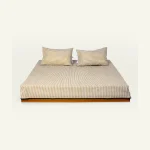 Wheat Beige with Pearl Green Silent Stripes Flat Bedsheet shown made up on a low wooden platform bed with two matching pillows