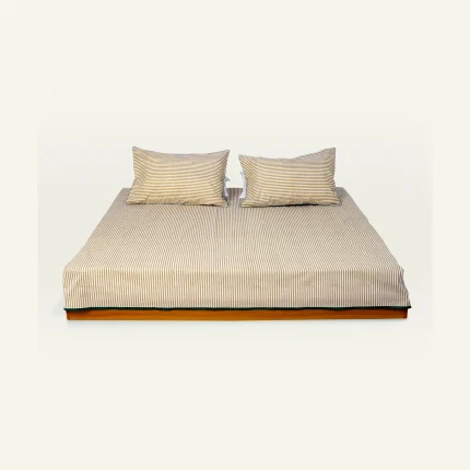 Wheat Beige with Pearl Green Silent Stripes Flat Bedsheet shown made up on a low wooden platform bed with two matching pillows