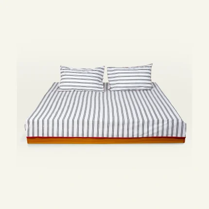 Cloudy Black with Candy Red Muted Layers Flat Bedsheet shown made up on a low wooden platform bed with two matching pillows