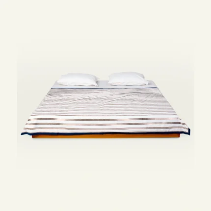 Mocha Brown with Haze Indigo Muted Layers Dohar shown made up on a low wooden platform bed with two matching pillows