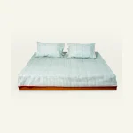 Pearl Green with Candy Red Pure Stripes Flat Bedsheet shown made up on a low wooden platform bed with two matching pillows