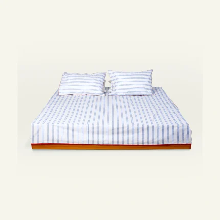 Dreamy Blue with Candy Red Muted Layers Flat Bedsheet shown made up on a low wooden platform bed with two matching pillows