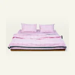 Berry Pink with Pearl Green Pure Stripes bed linen shown made up on a low wooden platform bed with two matching pillows