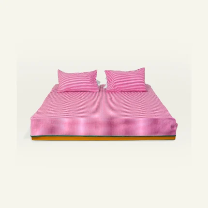 Berry Pink with Pearl Green Silent Stripes Flat Bedsheet shown made up on a low wooden platform bed with two matching pillows