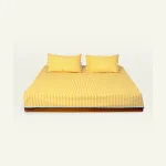 Mellow Yellow with Misty Blue Silent Stripes Flat Bedsheet shown made up on a low wooden platform bed with two matching pillows