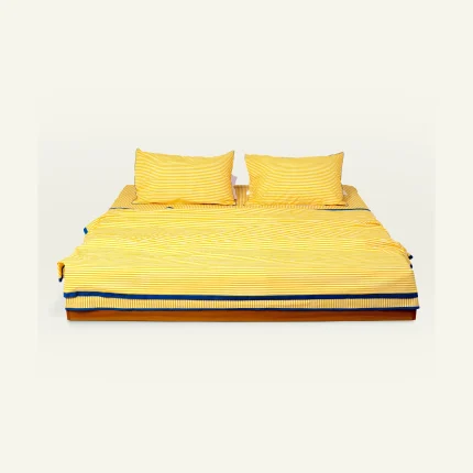 Mellow Yellow with Misty Blue Silent Stripes bed linen shown made up on a low wooden platform bed with two matching pillows